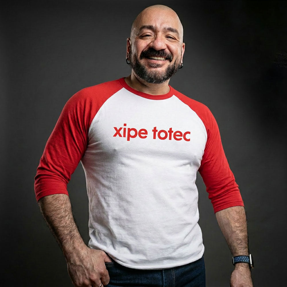 Xipe Totec 3/4 baseball tee: white body, red raglan sleeves, name printed in red across the chest.